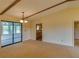 A spacious living room with beige carpet and wooden ceiling beams with a view to the outside sunroom at 133 Dailey Mill Rd, Mcdonough, GA 30253