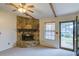 Cozy living room with a stone fireplace and ceiling fan, bathed in natural light from nearby windows at 133 Dailey Mill Rd, Mcdonough, GA 30253