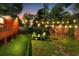 Cozy backyard with a fire pit, green chairs, wooden fence, string lights, and lush green grass at 1518 Langston Sw Ave, Atlanta, GA 30310