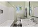 Bathroom featuring light green walls, a toilet, a white sink, and a bathtub at 1518 Langston Sw Ave, Atlanta, GA 30310