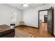 Bedroom featuring a wood floor, bright white walls, a ceiling fan, and a view into another room at 1518 Langston Sw Ave, Atlanta, GA 30310