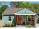 Charming bungalow-style home featuring a red door, green siding, and a well-manicured front yard at 1518 Langston Sw Ave, Atlanta, GA 30310