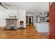 Open concept living space with hardwood floors, a brick fireplace, and seamless flow to the kitchen at 1518 Langston Sw Ave, Atlanta, GA 30310