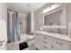 Bathroom featuring a tub with shower, neutral tile surround, single sink and vanity at 160 Brookhollow Trce, Alpharetta, GA 30022