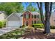 Charming two-story brick home featuring black shutters, lush landscaping, and a well-manicured lawn at 160 Brookhollow Trce, Alpharetta, GA 30022