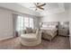 This is a primary bedroom featuring a tray ceiling, neutral decor, and a round chaise lounge at 160 Brookhollow Trce, Alpharetta, GA 30022