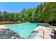 Community swimming pool with lounge chairs surrounded by green trees and shrubbery at 160 Brookhollow Trce, Alpharetta, GA 30022