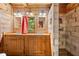 Rustic bathroom featuring a double vanity, wood cabinets, and a unique stone shower, blending natural elements at 3401 Clay Rd, Austell, GA 30106
