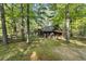 View of log cabin, surrounded by lush greenery and a rustic wooden fence, showcasing its natural setting at 3401 Clay Rd, Austell, GA 30106