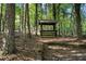 View of a log-framed gazebo nestled amongst tall trees and natural foliage in a woodland setting at 3401 Clay Rd, Austell, GA 30106