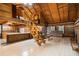 Open log cabin living area with stairs, a loft and a rustic stone fireplace at 3401 Clay Rd, Austell, GA 30106