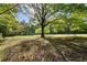 View of the expansive grassy lot featuring mature trees and an open field at 3401 Clay Rd, Austell, GA 30106