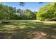 Image of the large, green lot featuring mature trees and an open field at 3401 Clay Rd, Austell, GA 30106
