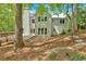 Rear exterior of the home featuring a spacious deck, stone patio, and well-maintained landscaping at 4380 Laurian Nw Dr, Kennesaw, GA 30144