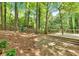 Lush backyard view featuring a wooden deck, mature trees, and a peaceful setting with privacy fence at 4380 Laurian Nw Dr, Kennesaw, GA 30144