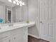 Bathroom vanity and countertop with mirror and decorative items, next to a white door at 4380 Laurian Nw Dr, Kennesaw, GA 30144