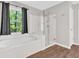 Bright bathroom featuring a soaking tub, glass enclosed shower, and a large window at 4380 Laurian Nw Dr, Kennesaw, GA 30144