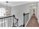Upstairs hallway with hardwood floors, modern light fixtures, and black metal railing at 4380 Laurian Nw Dr, Kennesaw, GA 30144