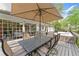 An expansive deck with outdoor dining under an umbrella, seamlessly connected to the home through large windows at 4813 Fernie Ne Ct, Marietta, GA 30068