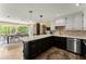 A spacious kitchen features a large island with white countertop and black cabinets and stainless steel appliances at 4813 Fernie Ne Ct, Marietta, GA 30068