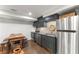Basement kitchenette with stainless appliances, dark cabinets, and wood table provides a functional space at 4813 Fernie Ne Ct, Marietta, GA 30068