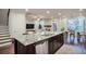 Open-concept kitchen island with stainless steel dishwasher, granite countertops, and view of the living room and dining area at 5022 Towneship Creek Rd, Roswell, GA 30075