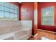 Bathtub with a tiled surround and window offering plenty of natural light at 5840 Harrier Ln, Atlanta, GA 30349