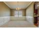 Spacious dining room featuring wainscoting, a chandelier, and a large window at 5840 Harrier Ln, Atlanta, GA 30349