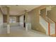 Open-concept living area featuring decorative columns, wainscotting, and staircase at 5840 Harrier Ln, Atlanta, GA 30349