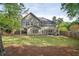 Lush backyard with a covered patio and a well-maintained lawn surrounded by mature trees at 899 Fairwood Nw Way, Acworth, GA 30101