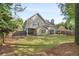 Spacious fenced backyard with lush grass, mature trees, and a covered patio area at 899 Fairwood Nw Way, Acworth, GA 30101