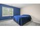 Bedroom featuring a blue accent wall, soft carpet, and bright window at 899 Fairwood Nw Way, Acworth, GA 30101