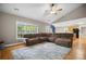 Expansive living room featuring a large sectional sofa, hardwood floors, and abundant natural light from the windows at 899 Fairwood Nw Way, Acworth, GA 30101