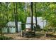 Private wooded backyard featuring a rustic fire pit surrounded by lush greenery at 1121 Dawn View Nw Ln, Atlanta, GA 30327