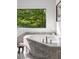 Modern bathroom with a raised bathtub and granite tile, well lit by a bright window at 1121 Dawn View Nw Ln, Atlanta, GA 30327