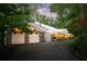 Unique modern home exterior with a striking white roof, two-car garage, and lush landscaping at 1121 Dawn View Nw Ln, Atlanta, GA 30327