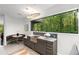 A cozy kitchenette with granite countertops, a stone sink, and a view of the woods through a large window at 1121 Dawn View Nw Ln, Atlanta, GA 30327