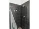 Modern bathroom with a frameless glass shower and black tiled walls at 1121 Dawn View Nw Ln, Atlanta, GA 30327