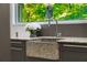 Close-up of the stone sink with granite countertop and a beautiful view of the surrounding nature through the window at 1121 Dawn View Nw Ln, Atlanta, GA 30327