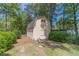 Charming backyard barn with a gray shingled roof, light yellow siding and a double door entrance at 1924 Windburn Ct, Snellville, GA 30078