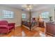 Cozy bedroom featuring a four-poster bed, hardwood floors, and ample natural light from two windows at 1924 Windburn Ct, Snellville, GA 30078