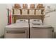 Modern laundry room with washer and dryer units, and shelving for storage at 1924 Windburn Ct, Snellville, GA 30078