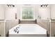Relaxing bathroom featuring a soaking tub with a window view, flanked by and sinks at 3875 Grandview Manor Dr, Cumming, GA 30028