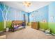 Cute bedroom with accent wall featuring cartoon trees and animals and hardwood furniture at 3875 Grandview Manor Dr, Cumming, GA 30028