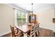 Elegant dining room features a wooden table with seating for eight, chandelier, and large window at 3875 Grandview Manor Dr, Cumming, GA 30028