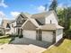 Exterior side view of a home with a three-car garage, well-kept lawn, and a combination of brick and siding at 3875 Grandview Manor Dr, Cumming, GA 30028