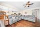 Spacious living room with large sectional sofa, hardwood floors, and decorative ceiling fan at 3875 Grandview Manor Dr, Cumming, GA 30028