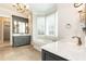 A well-lit bathroom features double sinks, vanity, and a soaking tub with plantation shutters at 4266 Paces Ferry Road Se, Atlanta, GA 30339