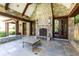 An outdoor stone fireplace and patio with dark wood ceiling beams and a stone surround at 4266 Paces Ferry Road Se, Atlanta, GA 30339