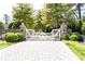 Elegant gated entrance with stone pillars, a white gate, and a meticulously paved driveway at 4266 Paces Ferry Road Se, Atlanta, GA 30339